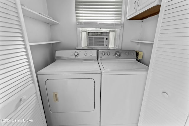 laundry area with washer and dryer, cooling unit, and cabinets