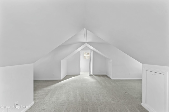 bonus room featuring light carpet and vaulted ceiling