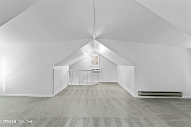 additional living space with vaulted ceiling, an AC wall unit, light carpet, and a baseboard radiator