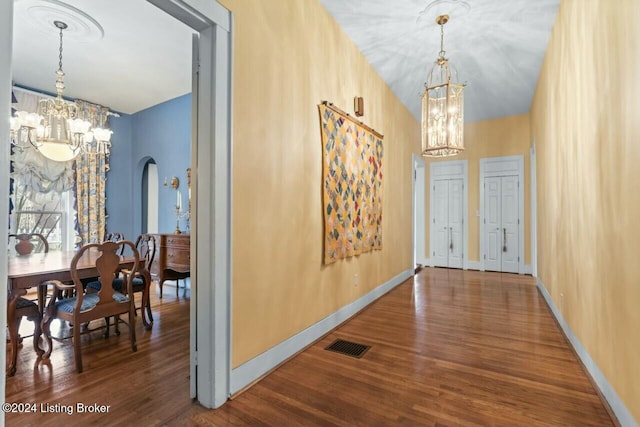 corridor with a chandelier and hardwood / wood-style floors