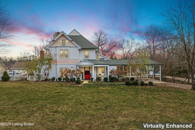 view of front of home featuring a porch, a carport, and a lawn