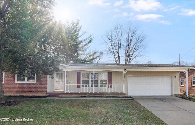 ranch-style house with covered porch, a garage, and a front lawn