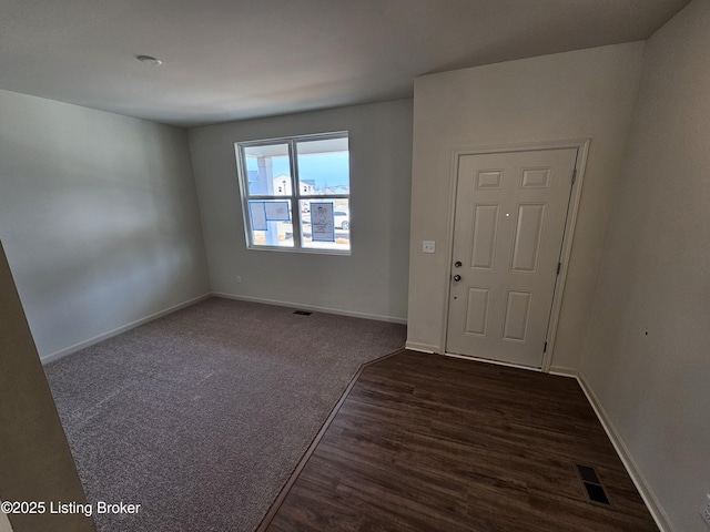 entryway with baseboards, visible vents, and dark wood finished floors