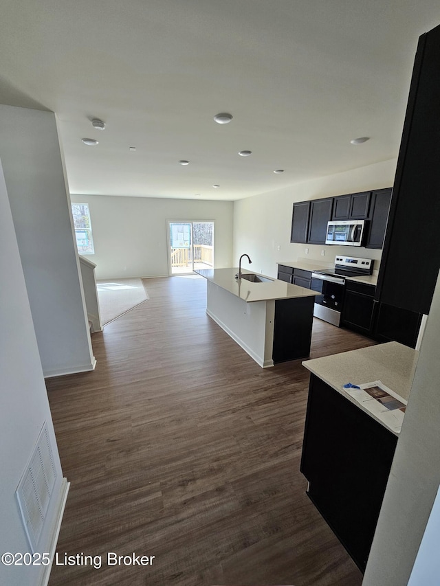 kitchen with a kitchen island with sink, stainless steel appliances, a sink, visible vents, and open floor plan