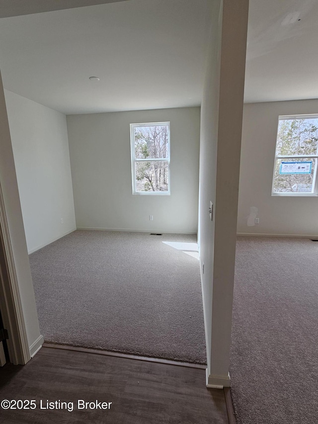 carpeted empty room with a wealth of natural light and visible vents