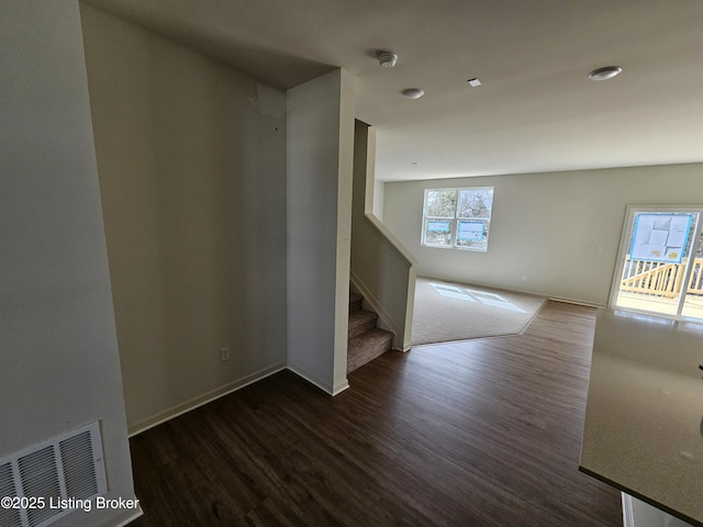 interior space with stairs, dark wood-type flooring, plenty of natural light, and visible vents