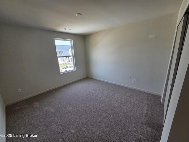 carpeted empty room with visible vents and baseboards