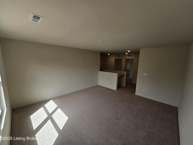 empty room featuring carpet floors, visible vents, and baseboards