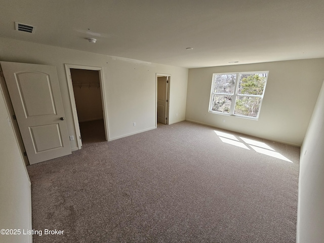 unfurnished bedroom with carpet floors, a closet, visible vents, and baseboards