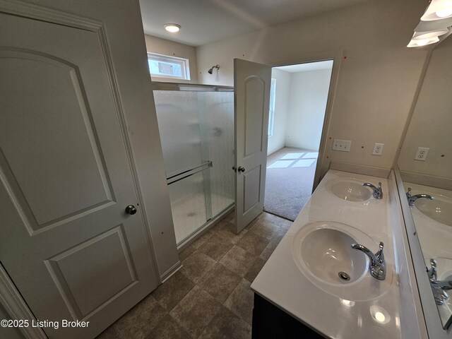 full bathroom featuring a sink, a shower stall, and double vanity