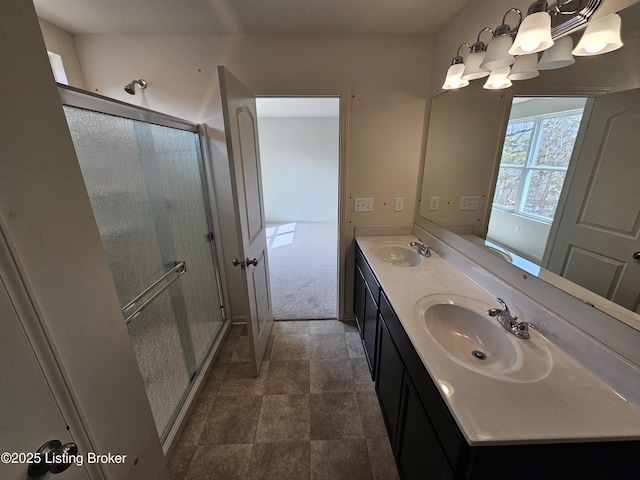 full bath with double vanity, a notable chandelier, a shower stall, and a sink