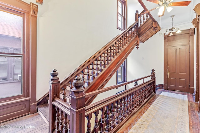 stairway with hardwood / wood-style flooring and a notable chandelier