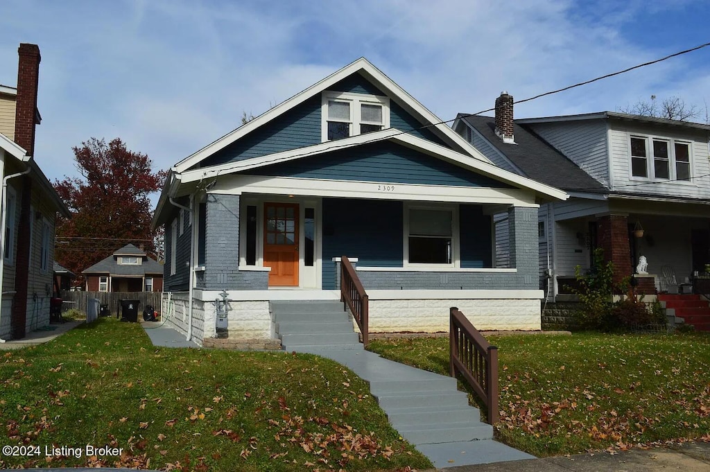 view of front of property with covered porch and a front lawn