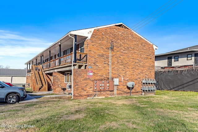 view of side of property featuring a yard and a balcony