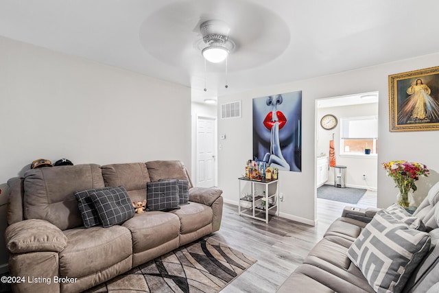 living room featuring ceiling fan and light hardwood / wood-style floors