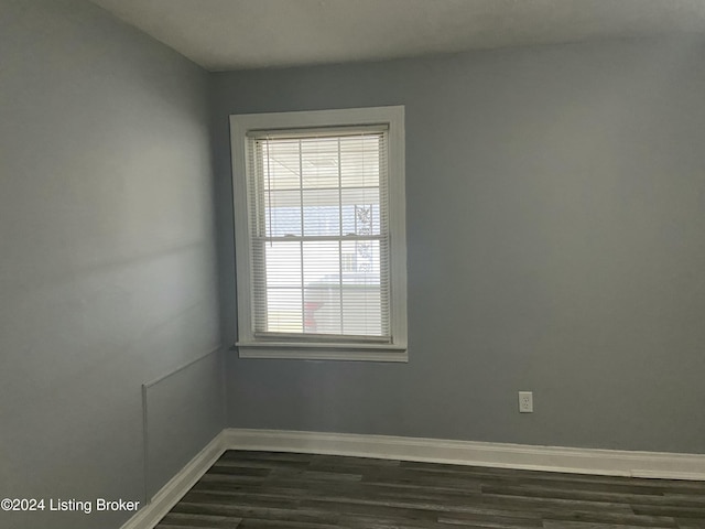 empty room with dark hardwood / wood-style flooring