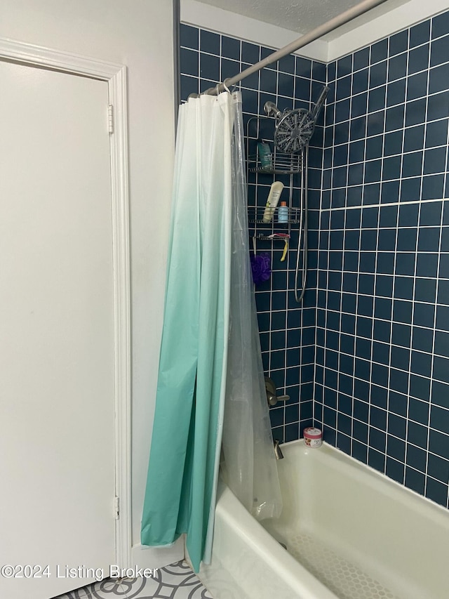 bathroom with a textured ceiling and shower / tub combo