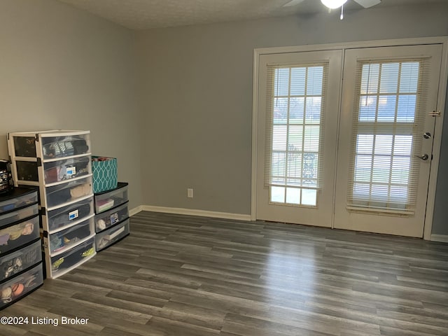 interior space featuring dark hardwood / wood-style floors, ceiling fan, and a textured ceiling