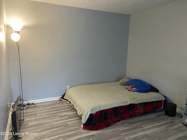 bedroom featuring a textured ceiling and hardwood / wood-style flooring