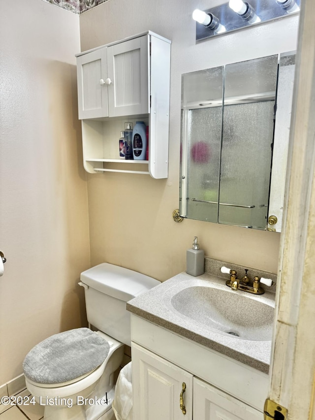 bathroom featuring vanity, toilet, and an enclosed shower