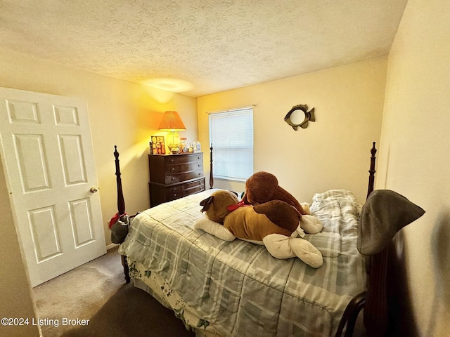 bedroom featuring carpet flooring and a textured ceiling