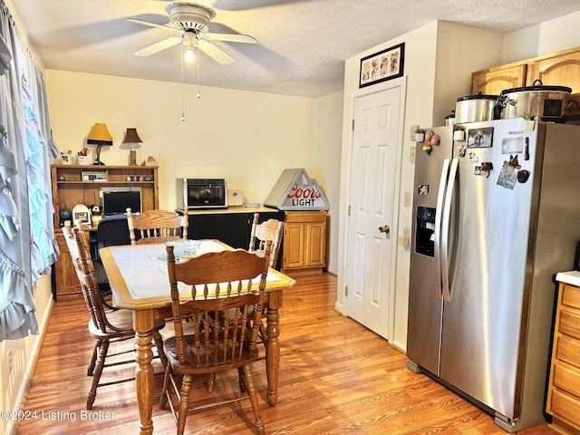 dining area featuring ceiling fan, light hardwood / wood-style floors, and a textured ceiling