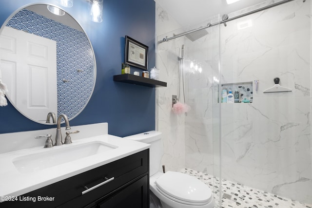 bathroom featuring vanity, an enclosed shower, and toilet