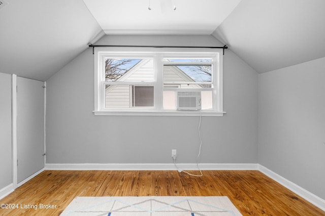 bonus room with cooling unit, wood-type flooring, and vaulted ceiling