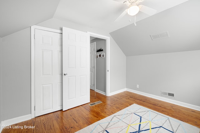 additional living space featuring hardwood / wood-style flooring, vaulted ceiling, and ceiling fan