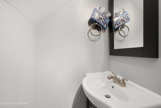 bathroom featuring vaulted ceiling and sink