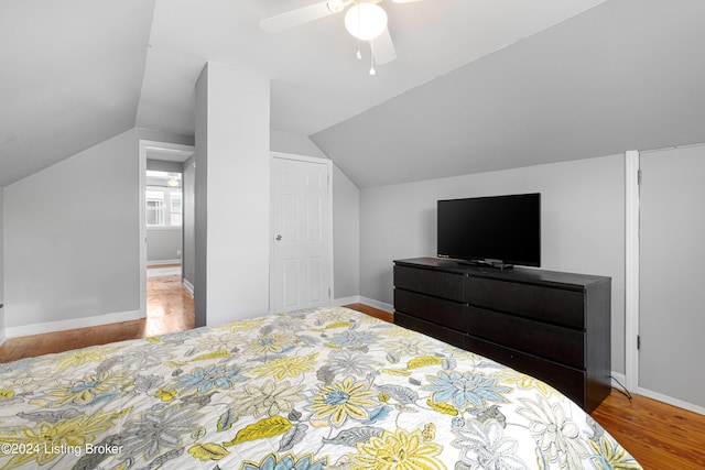 bedroom with hardwood / wood-style floors, vaulted ceiling, and ceiling fan