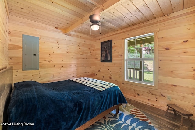 bedroom featuring electric panel, wood walls, beamed ceiling, and hardwood / wood-style flooring