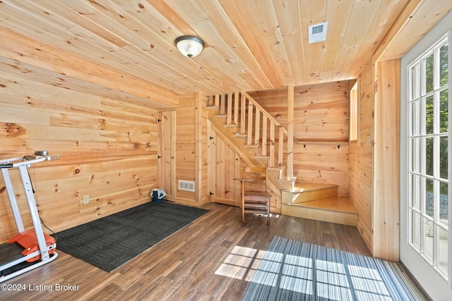 workout area featuring dark hardwood / wood-style flooring, wooden walls, and wood ceiling