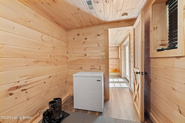 laundry area featuring wooden ceiling, dark wood-type flooring, and wood walls