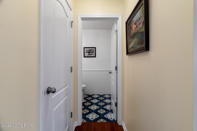 corridor with hardwood / wood-style flooring and tile walls