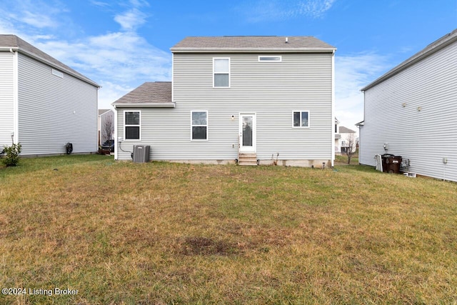 rear view of property featuring a yard and central AC