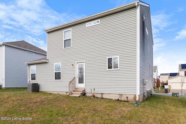 rear view of house with a lawn and central air condition unit