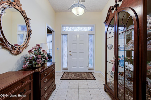 tiled entrance foyer featuring a textured ceiling