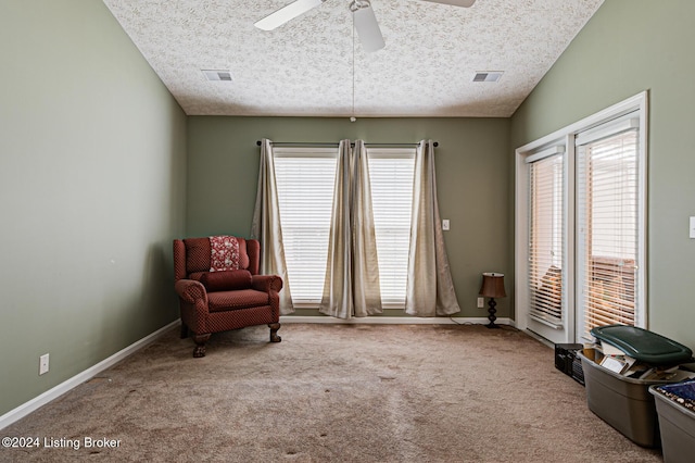 living area with carpet flooring, ceiling fan, vaulted ceiling, and a textured ceiling