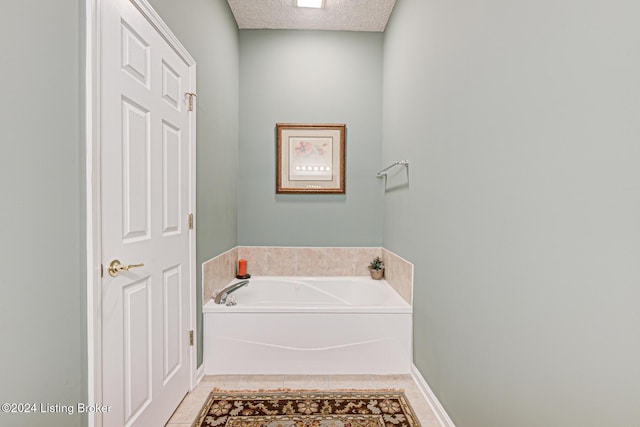 bathroom featuring tile patterned flooring, a textured ceiling, and a bathing tub