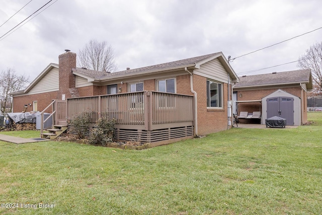 back of house featuring a lawn, a deck, and a storage shed