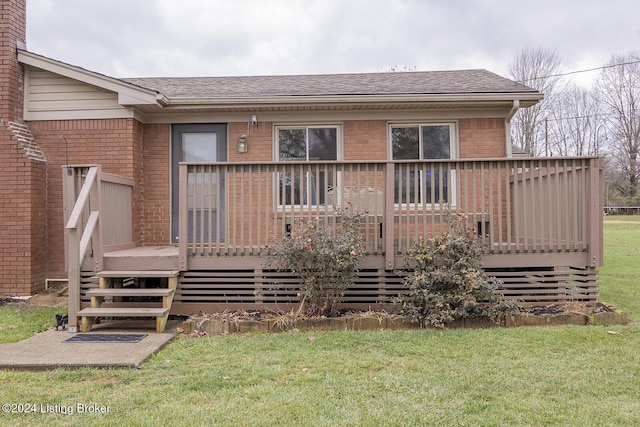 back of property with a lawn and a deck