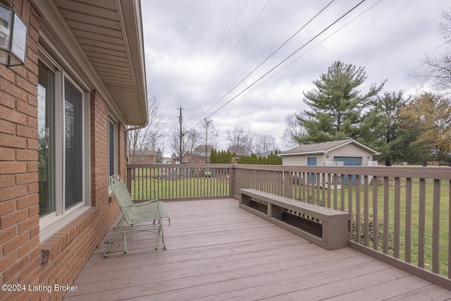 deck featuring an outbuilding, a yard, and a garage