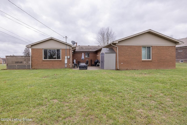 back of property with a storage shed, a yard, and a deck