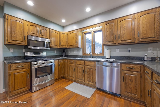 kitchen featuring appliances with stainless steel finishes, sink, and hardwood / wood-style floors