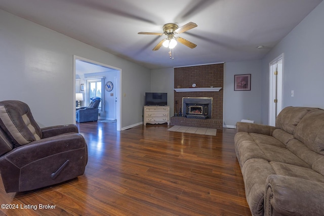 living room featuring ceiling fan, dark wood-type flooring, and a fireplace