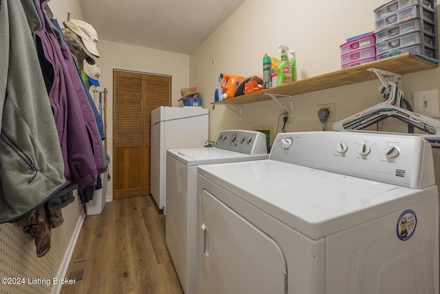 laundry room featuring light hardwood / wood-style flooring and washing machine and clothes dryer