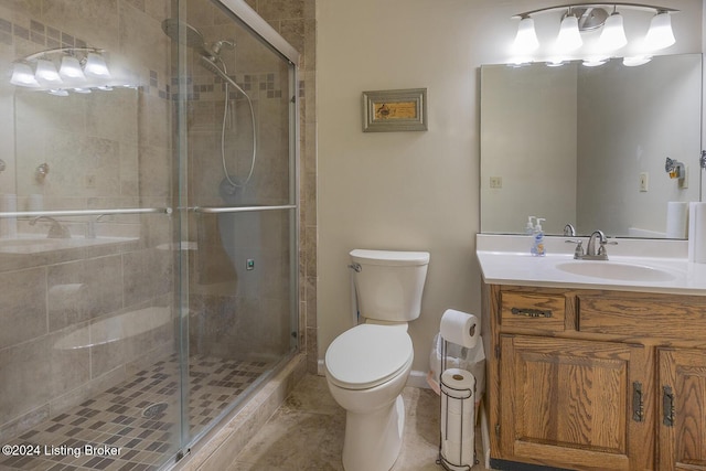 bathroom featuring an enclosed shower, vanity, tile patterned flooring, and toilet