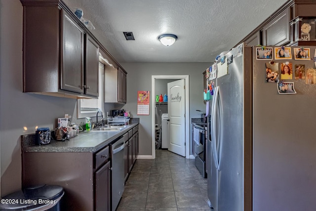 kitchen with a textured ceiling, dark brown cabinetry, sink, and stainless steel appliances