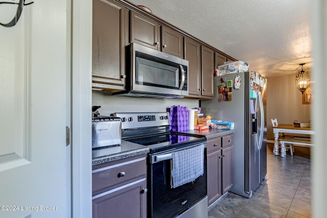 kitchen with an inviting chandelier, light tile patterned floors, a textured ceiling, appliances with stainless steel finishes, and dark brown cabinets